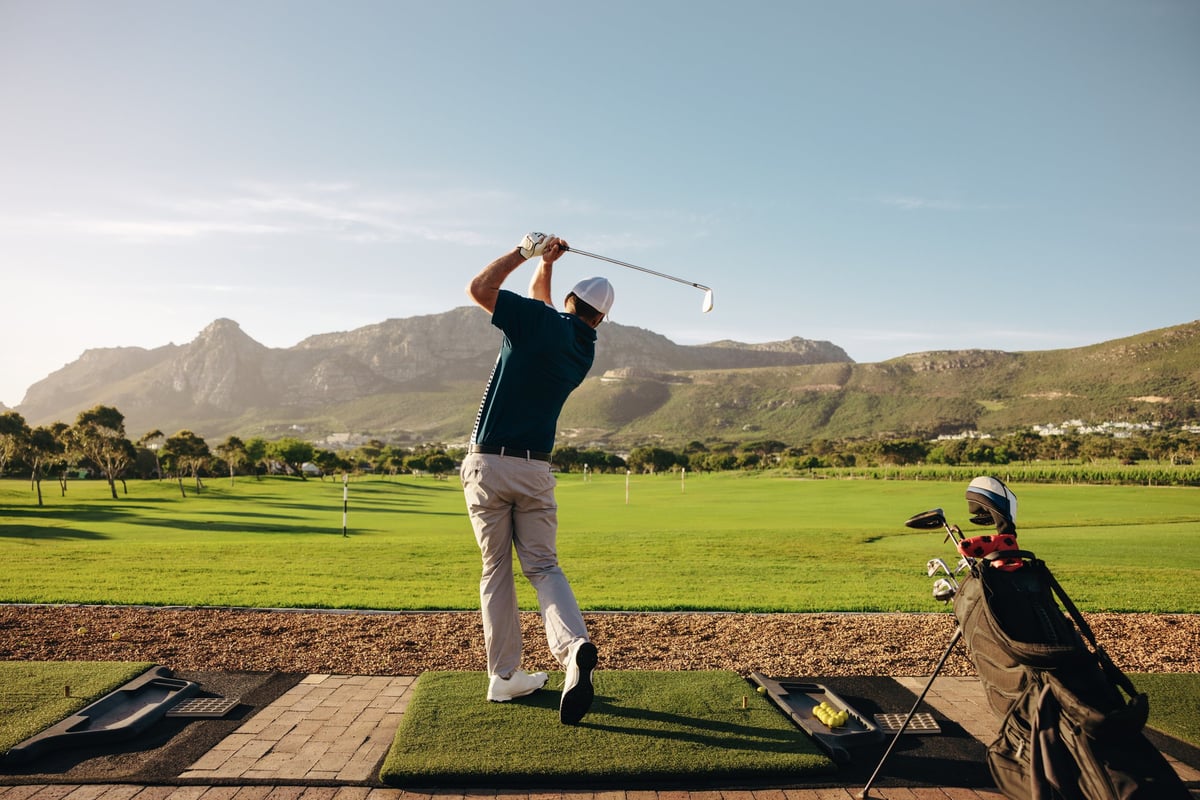 Male golfer taking a swing on a beautiful mountain course at a golf resort
