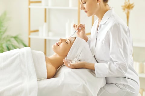 Young woman enjoying facial treatment at professional beauty salon